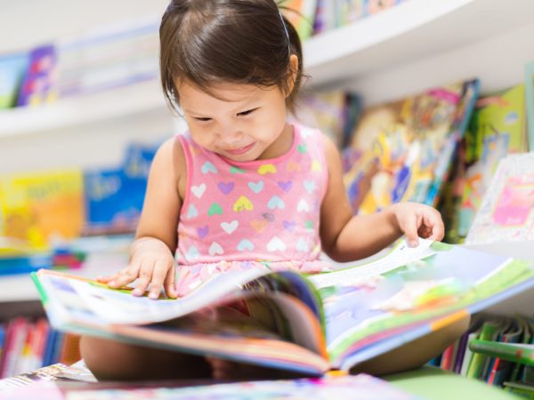 Little girl reading a book. Education.